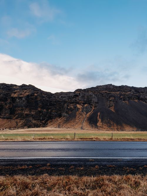 Free Breathtaking view of Iceland's rugged landscape and road under a clear blue sky. Stock Photo