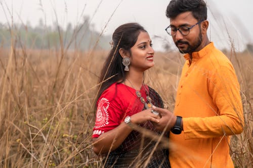 Couple in Traditional Clothing on Field