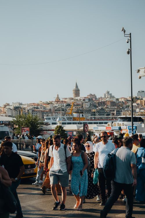Free A vibrant crowd fills the street with Istanbul's iconic Galata Tower in the background. Stock Photo