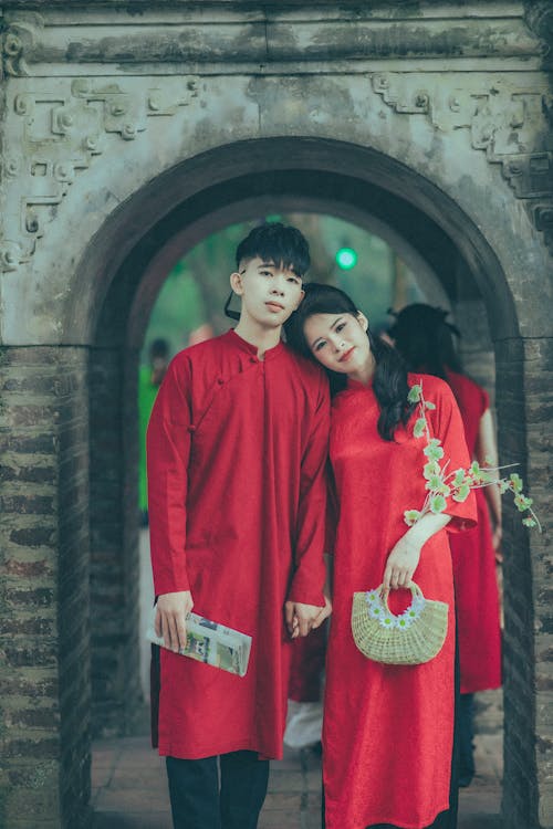 A couple in traditional clothing pose for a photo
