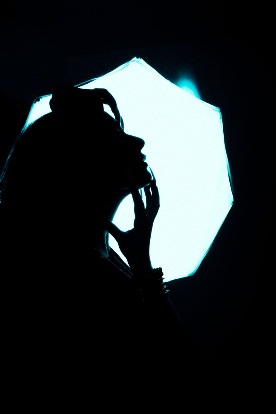 Photographer silhouetted against a blazing softbox mid-shoot