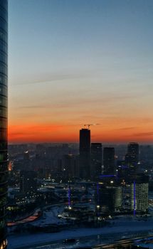 A breathtaking sunset over a modern cityscape with towering skyscrapers and a vibrant sky.