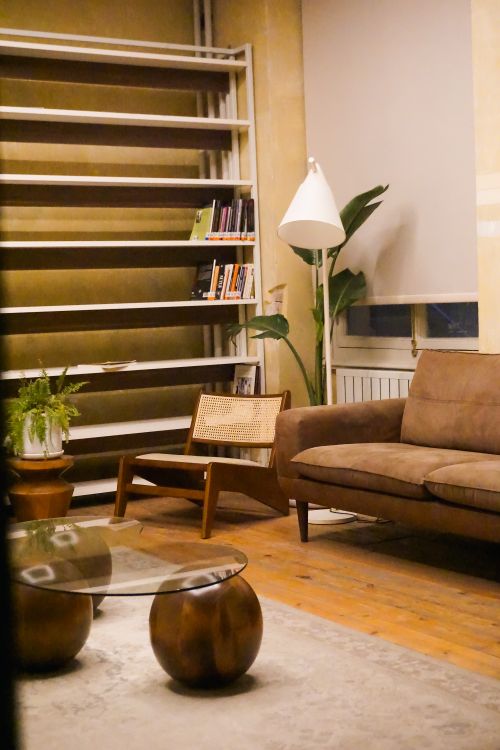 Free A cozy modern living room featuring a brown sofa, wooden furniture, and soft lighting, perfect for relaxation. Stock Photo