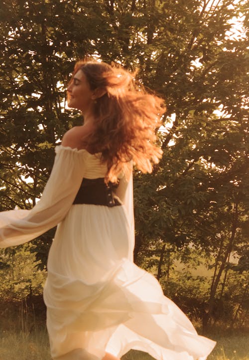 Back View of Woman in White Dress near Tree