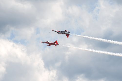 Free Dynamic capture of two Turkish Stars airplanes performing aerobatics in a cloudy sky. Stock Photo