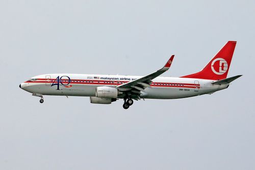 Free A Malaysian Airlines aircraft flying against a clear sky, showcasing aviation and travel. Stock Photo