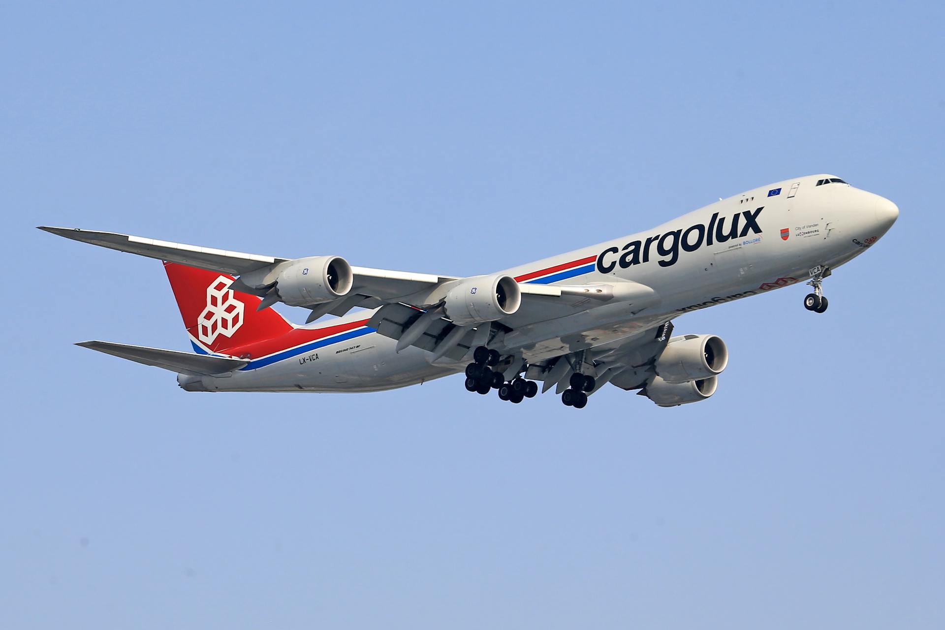 Cargolux Boeing 747-8 cargo aircraft flying under a clear blue sky.
