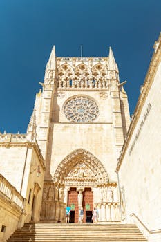 Stunning Gothic entrance of Burgos Cathedral in the bright daylight, showcasing intricate stonework.