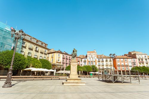 Free Colorful buildings and the Carlos II monument in Burgos, Spain's lively square under a clear blue sky. Stock Photo