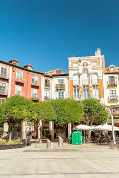 Colorful buildings and a lively square in Burgos, Spain, captured on a sunny day.