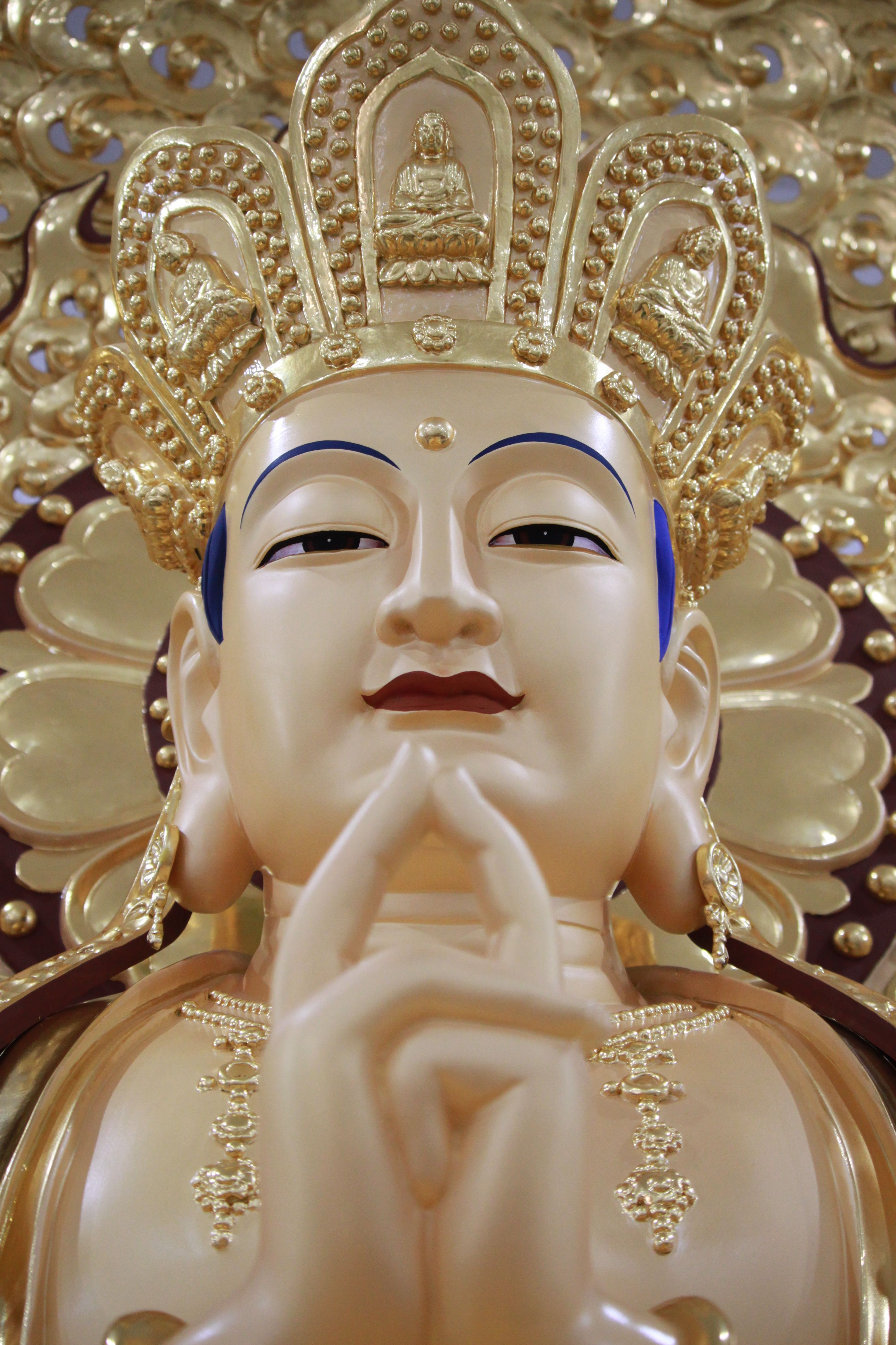 Close-up of a golden Buddha statue with intricate details and ornaments.