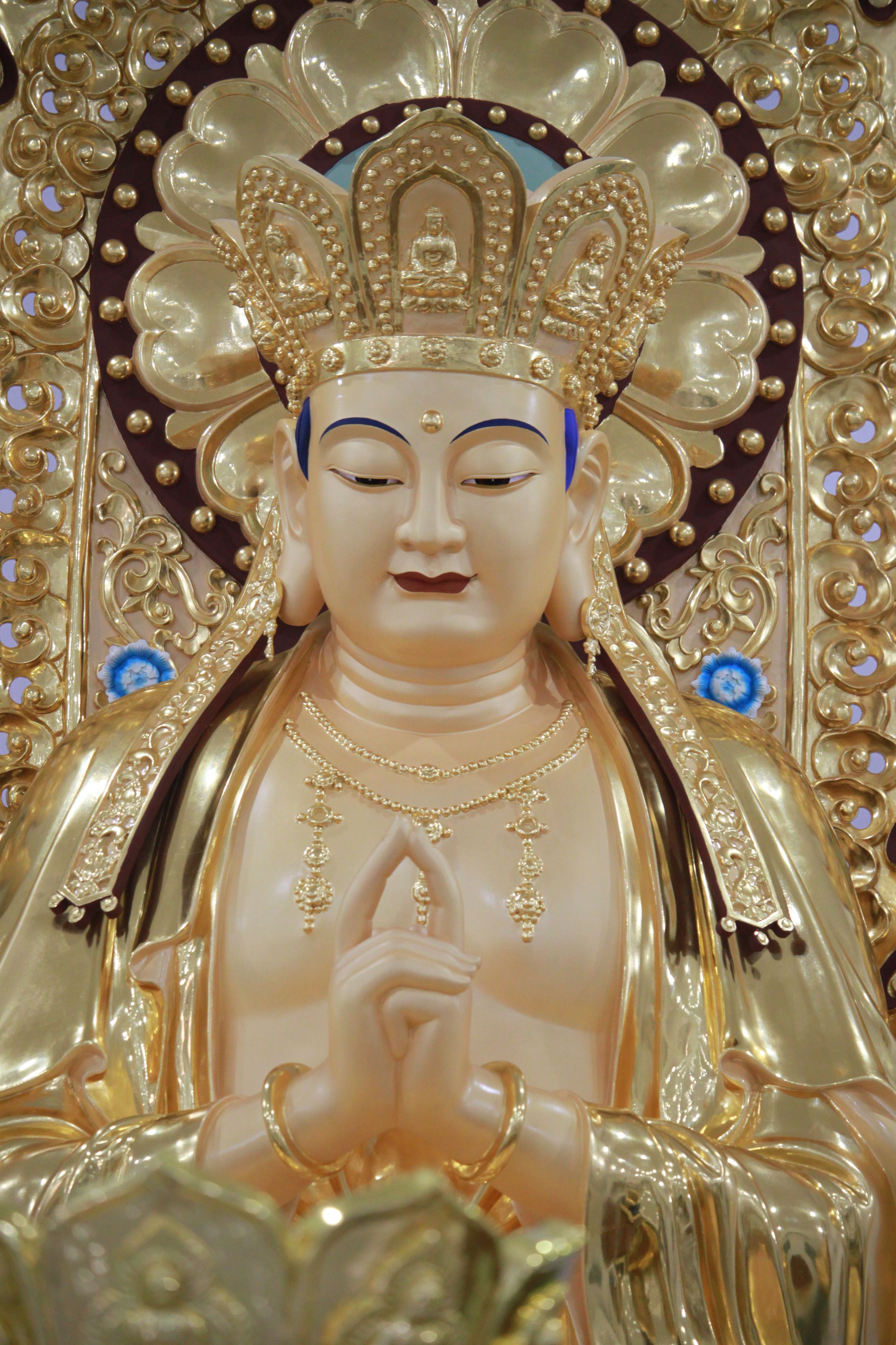 A detailed view of a golden Buddha statue with an ornate crown, symbolizing peace and serenity.
