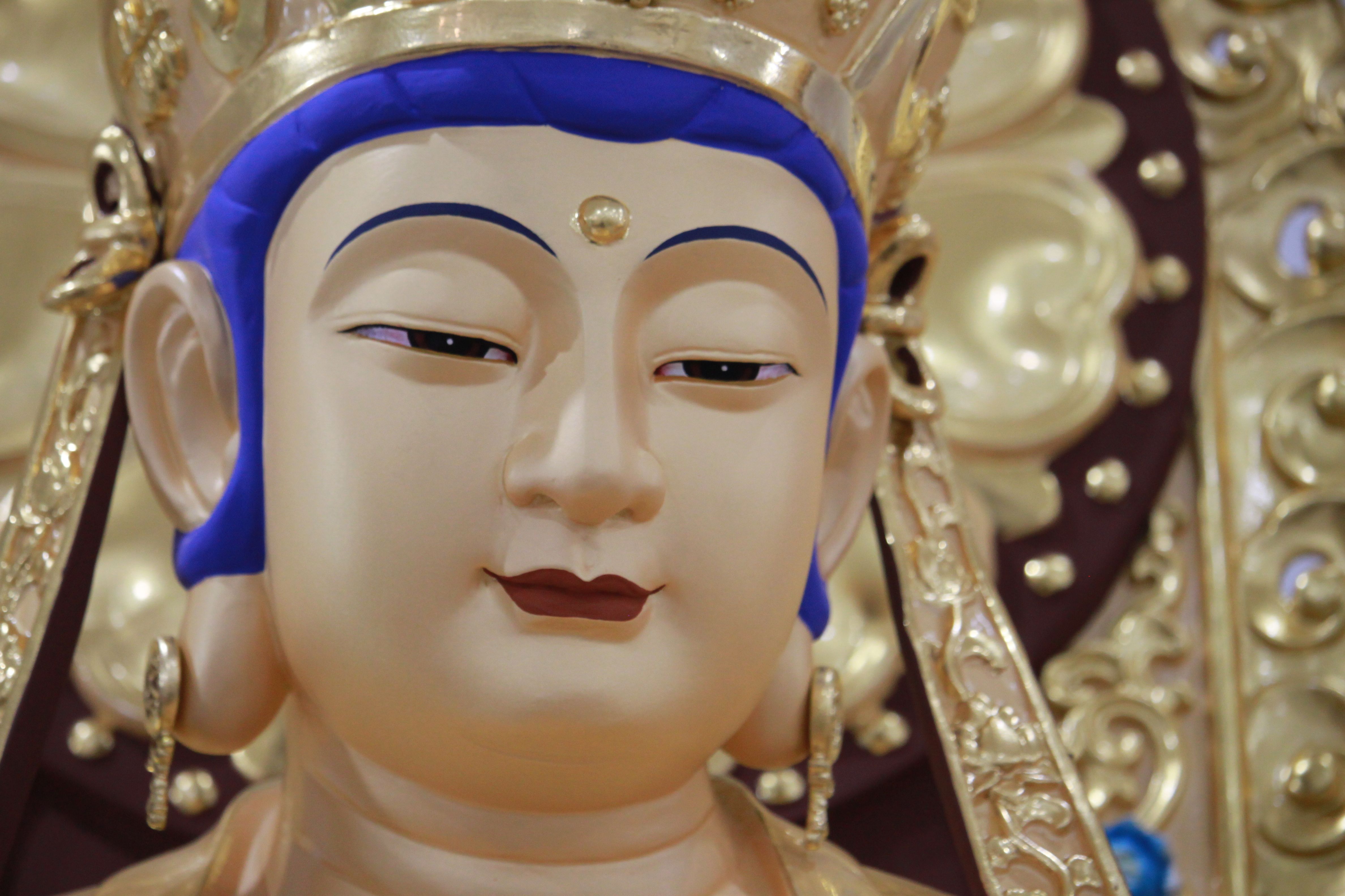 A detailed close-up photo of a serene Buddha statue with intricate gold detailing, symbolizing peace and spirituality.