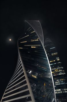 Dramatic night view of the illuminated Evolution Tower in Moscow.