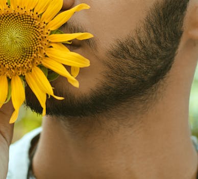 这是一张特写照片，照片中一名男子手持一朵充满活力的向日葵，展现了夏日的明亮