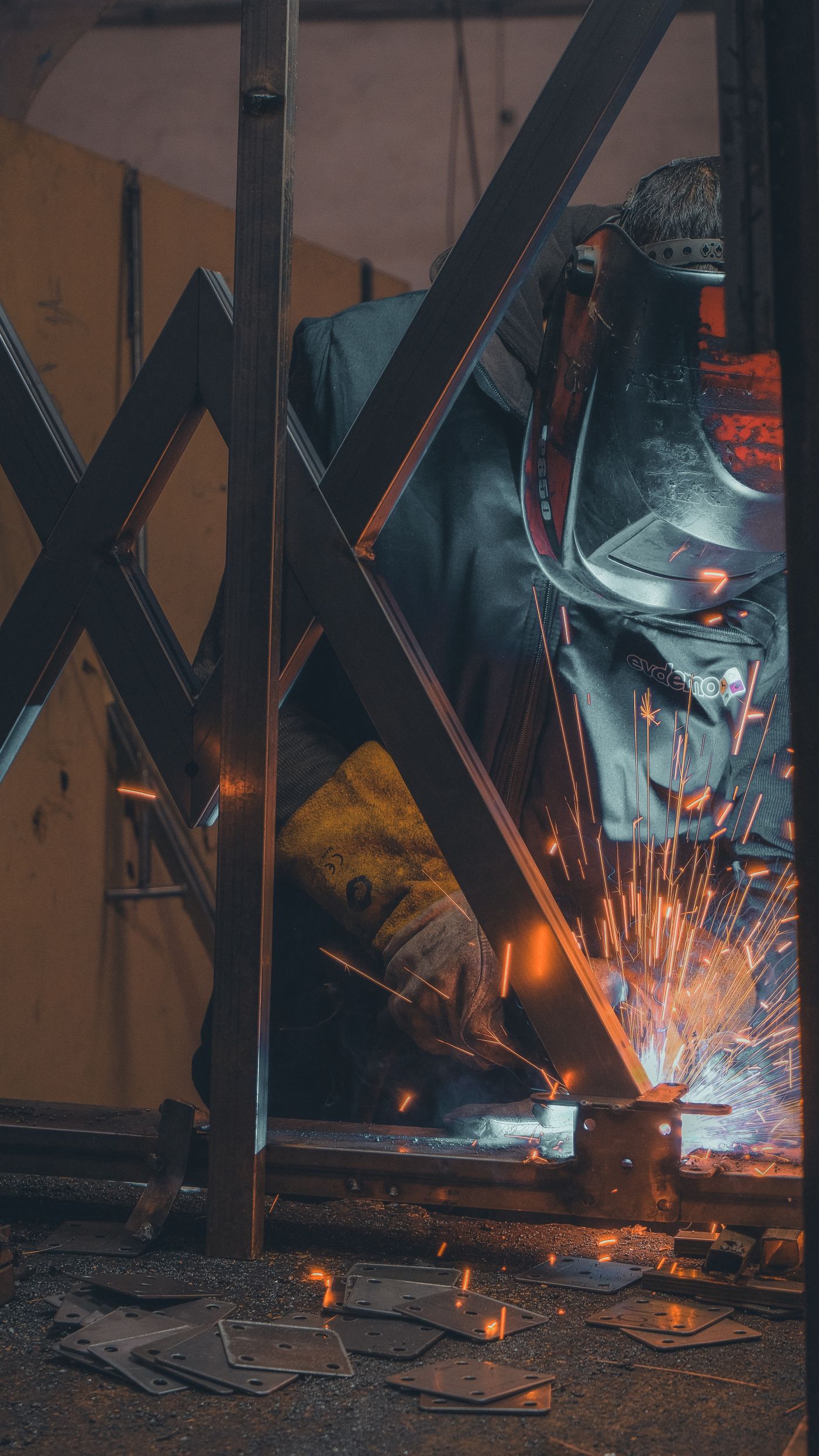 Craftsman forging the estate's ornamental iron gate frame in the shop