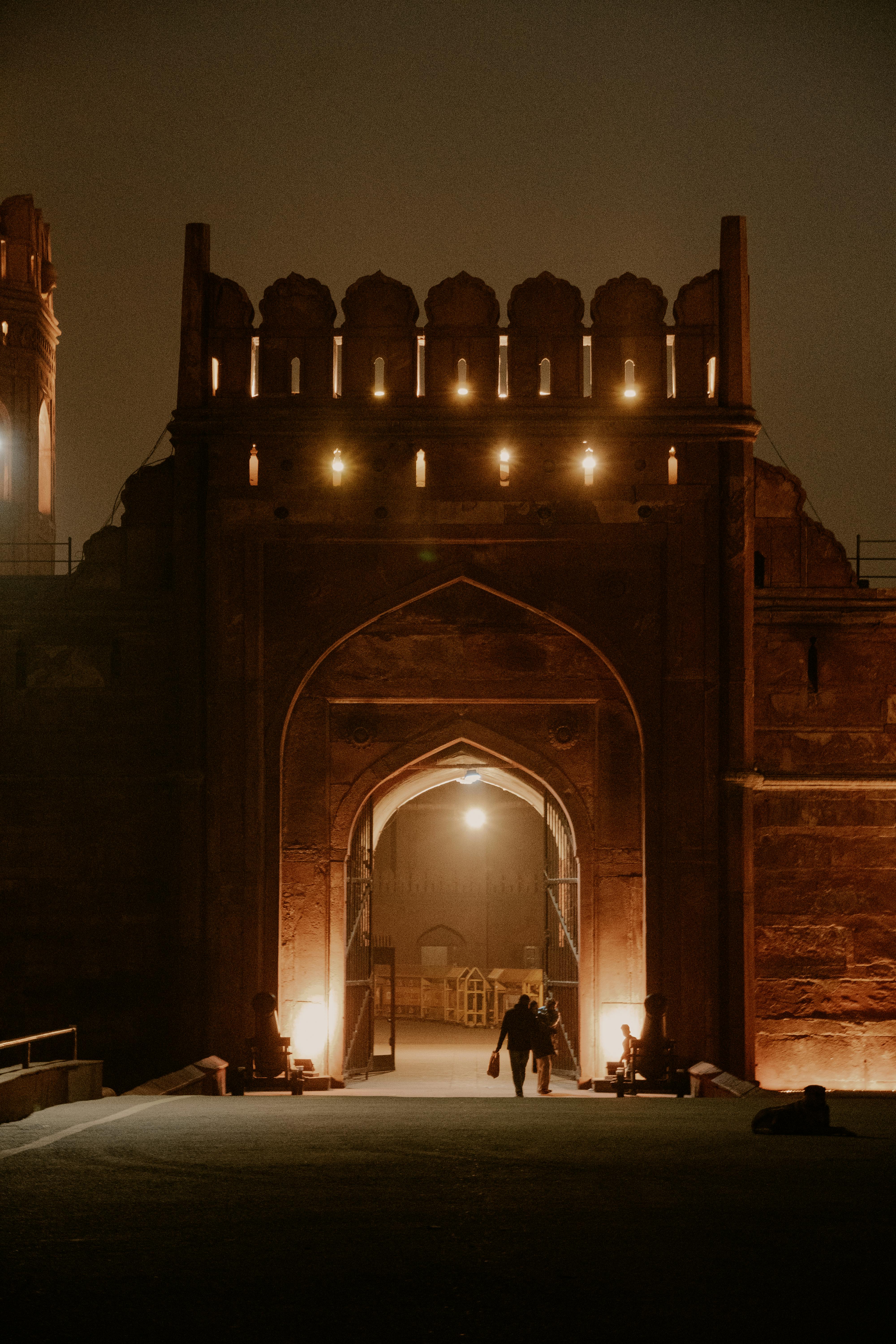 a couple walking through an archway at night