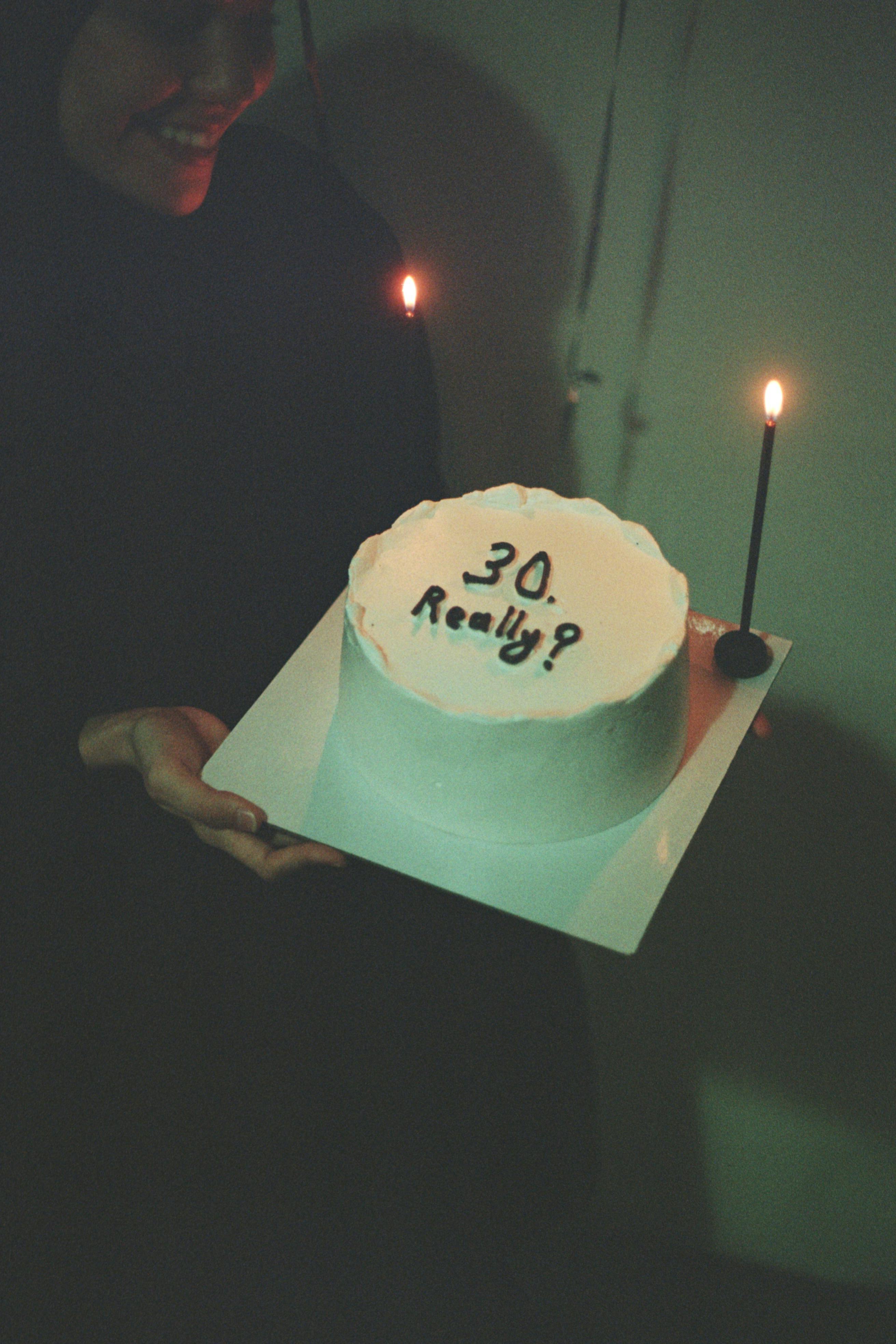 A joyous moment captured with a 30th birthday cake lit by candles.