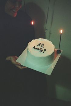 A joyous moment captured with a 30th birthday cake lit by candles.