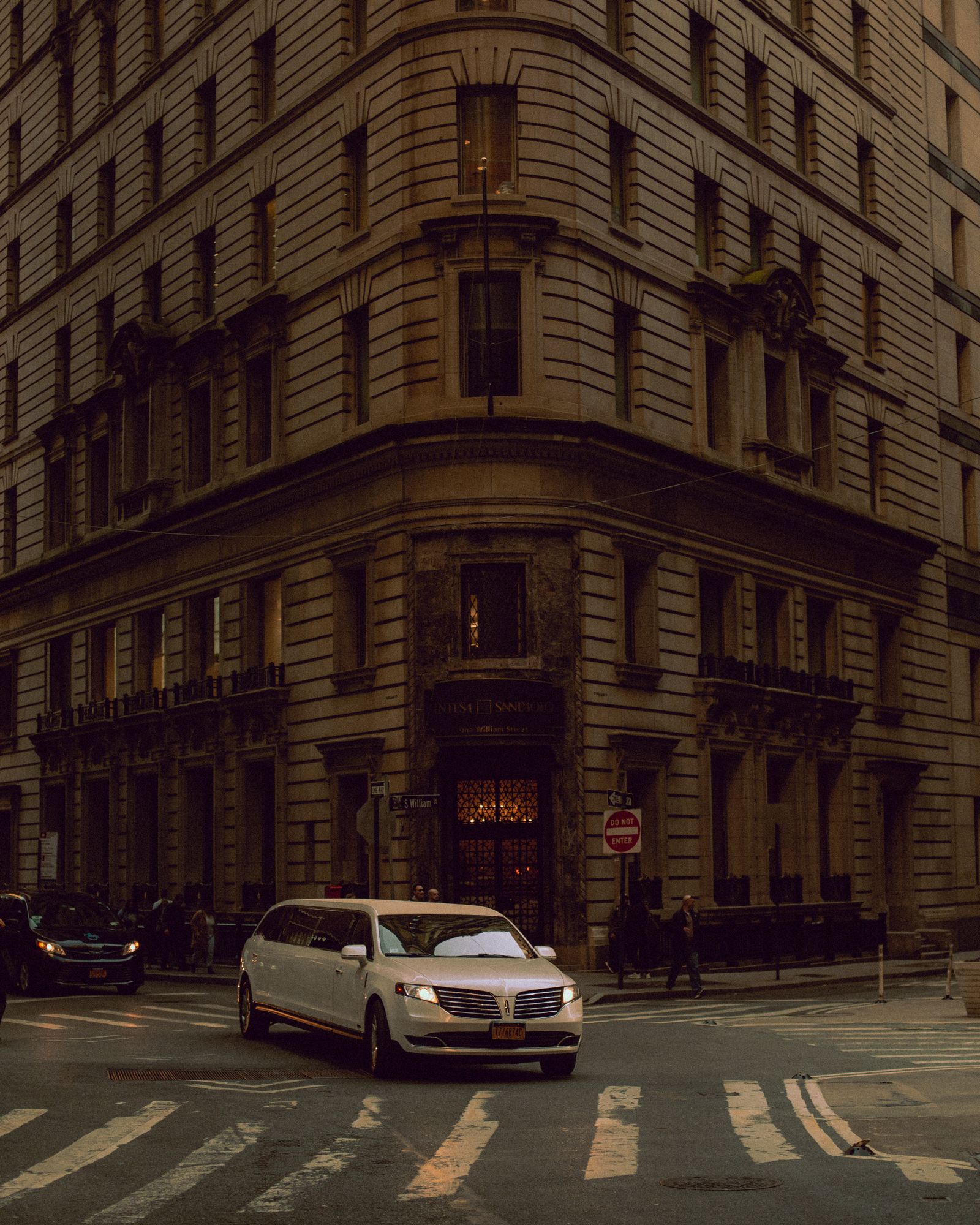 Chauffeured stretch limousine gliding through a city street at dusk