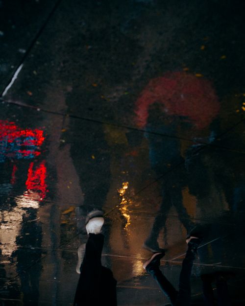 Free Artistic urban street scene with reflections of pedestrians in rain. Stock Photo