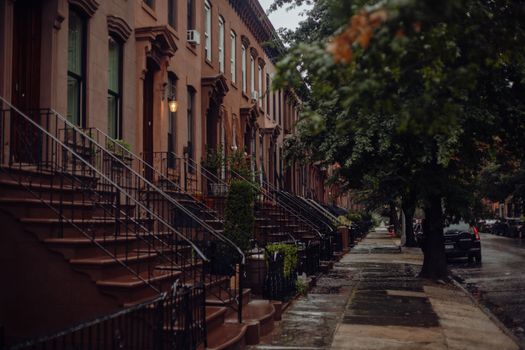 A rainy day in a historic New York neighborhood with classic brownstone buildings.