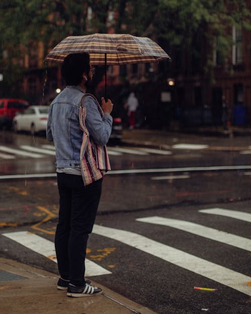 Man in Jean Jacket and with Umbrella in New York in Rain