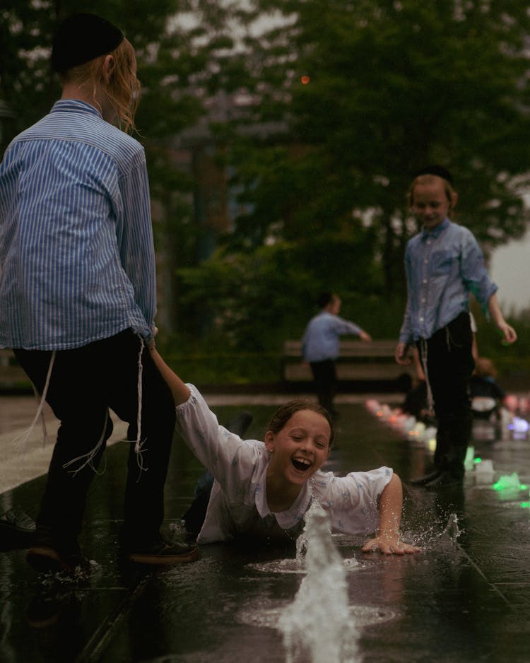 Girl And Boys Playing In Water