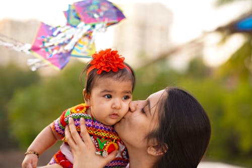 Mother Kissing Baby Girl