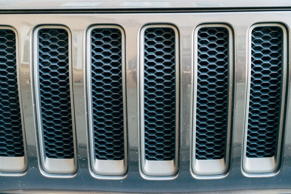 Detail einer Sitzbank mit Lüftungsgitter und Stauraumfront vor einem Heizkörper