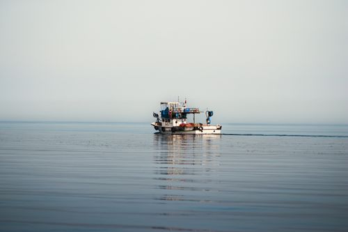 Free A lone fishing boat navigating calm seas, epitomizing tranquility and maritime life. Stock Photo