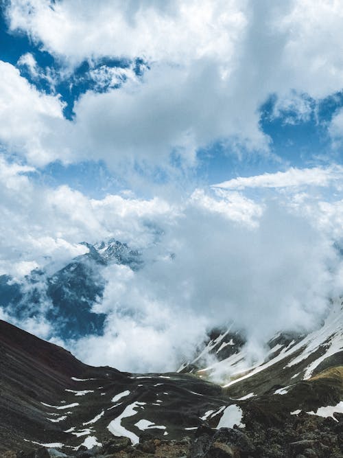 A mountain range with clouds and snow