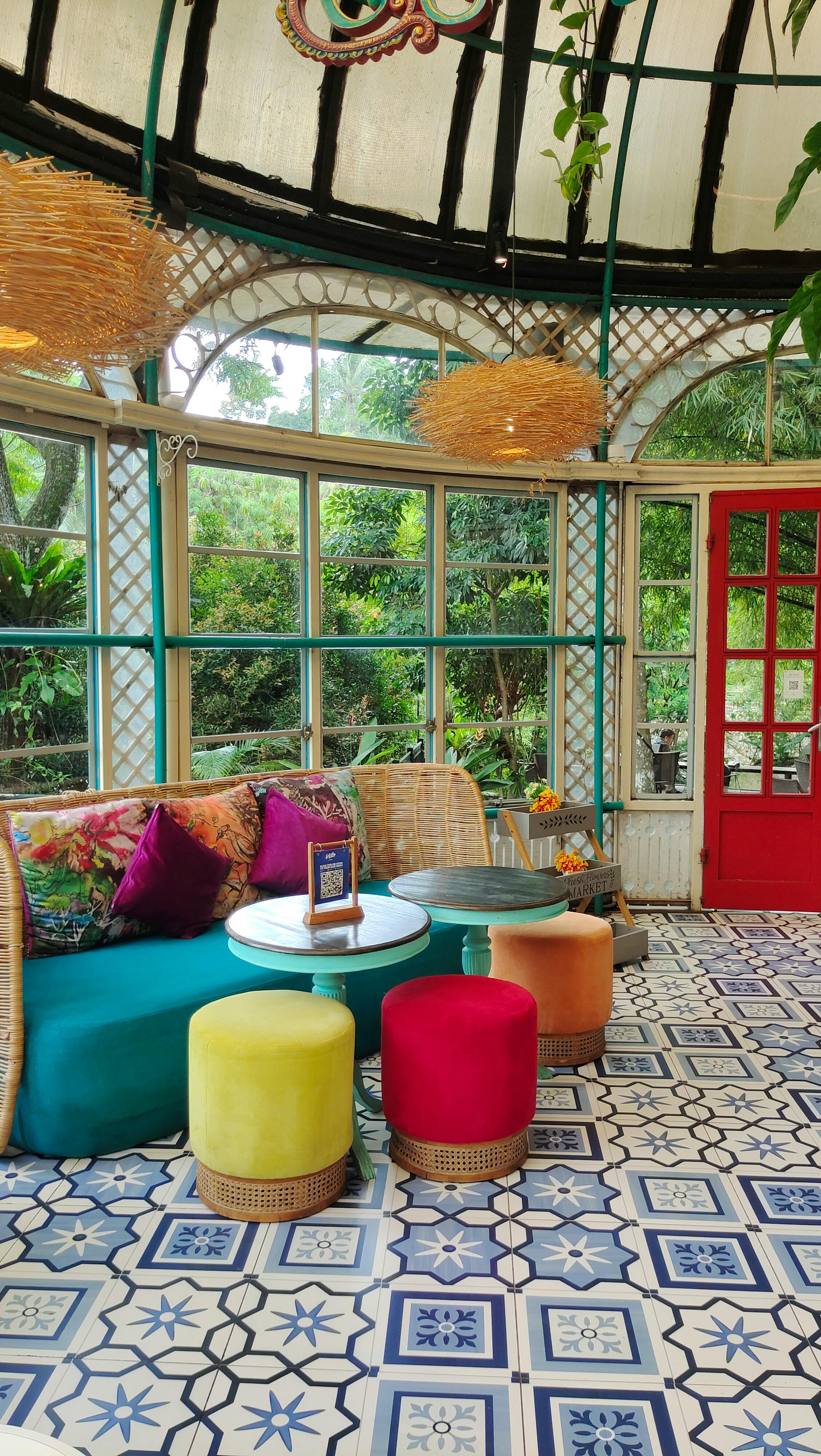 Vibrant bohemian room in West Java with colorful seating and natural light.