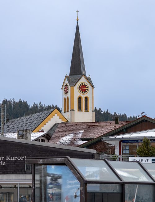 Free View of St. Peter and Paul Church tower in Oberstaufen, Germany with surrounding buildings. Stock Photo