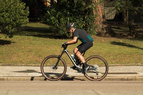 Free A person riding a bike on a sidewalk Stock Photo