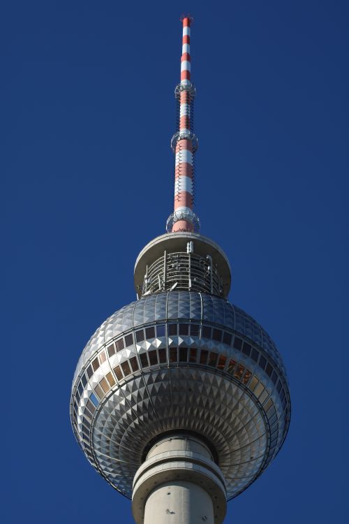 Free The Berliner Fernsehturm stands tall against a clear blue sky in Berlin, Germany. Stock Photo