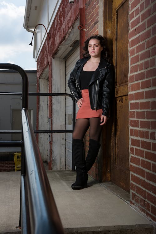 Model in a Leather Jacket and Red Mini Skirt Posing in an Alley