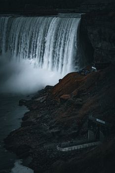 A breathtaking view of a powerful waterfall cascading over rugged cliffs at twilight. Perfect for travel inspiration.