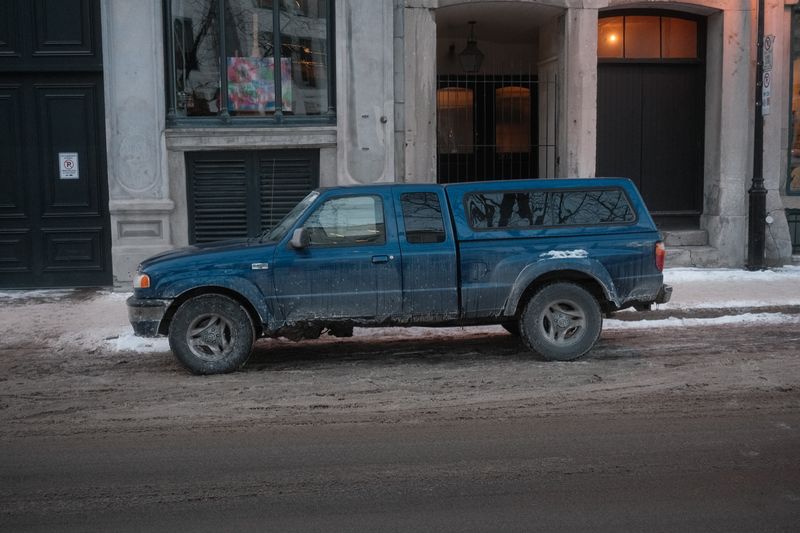 Blue pickup with a canopy parked on a snowy street, photo by Victor Lucas on Pexels