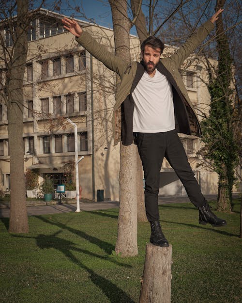 Man Posing on Tree Trunk at Park