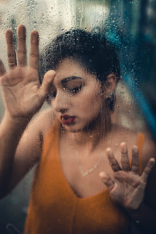 Woman Wearing Tank Top Touching Glass Panel
