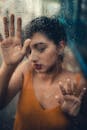 Woman Wearing Tank Top Touching Glass Panel