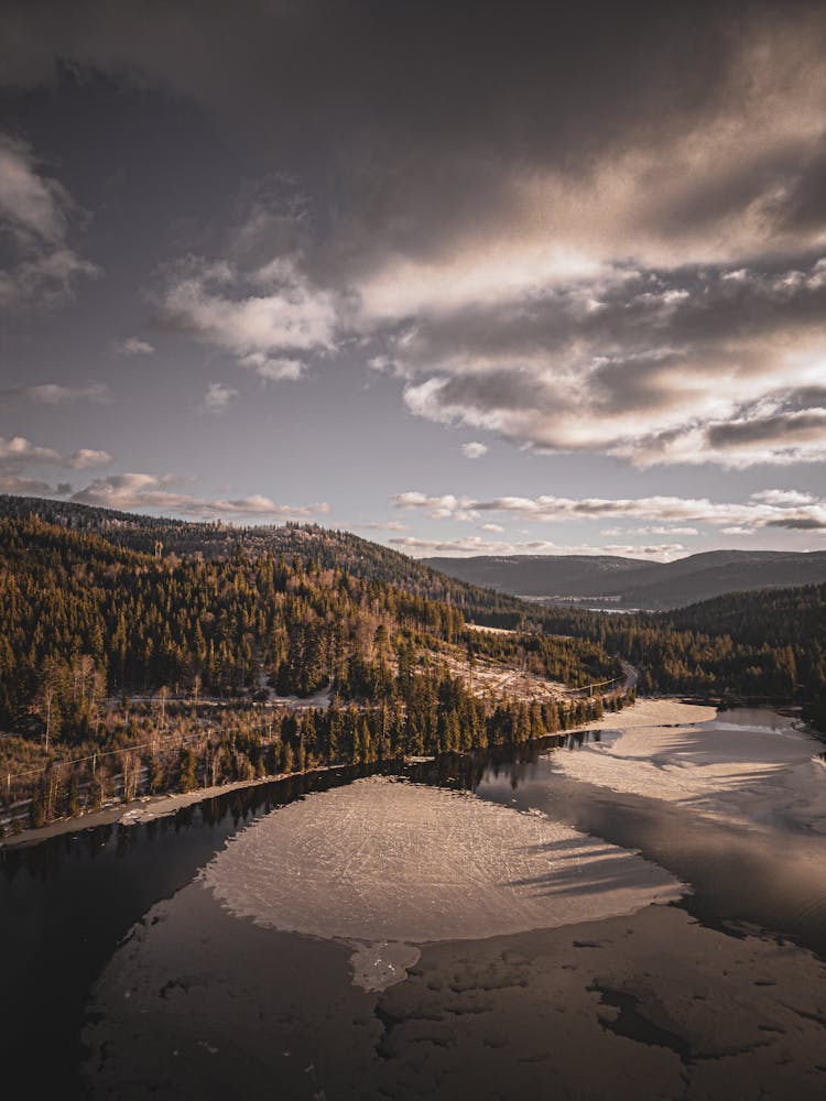 Aerial View Of A Frozen Lake Among Forest-covered Hills