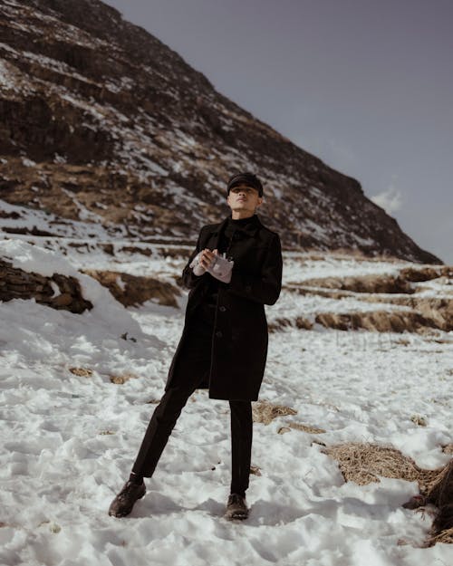 Man in Black Coat Standing in Snow