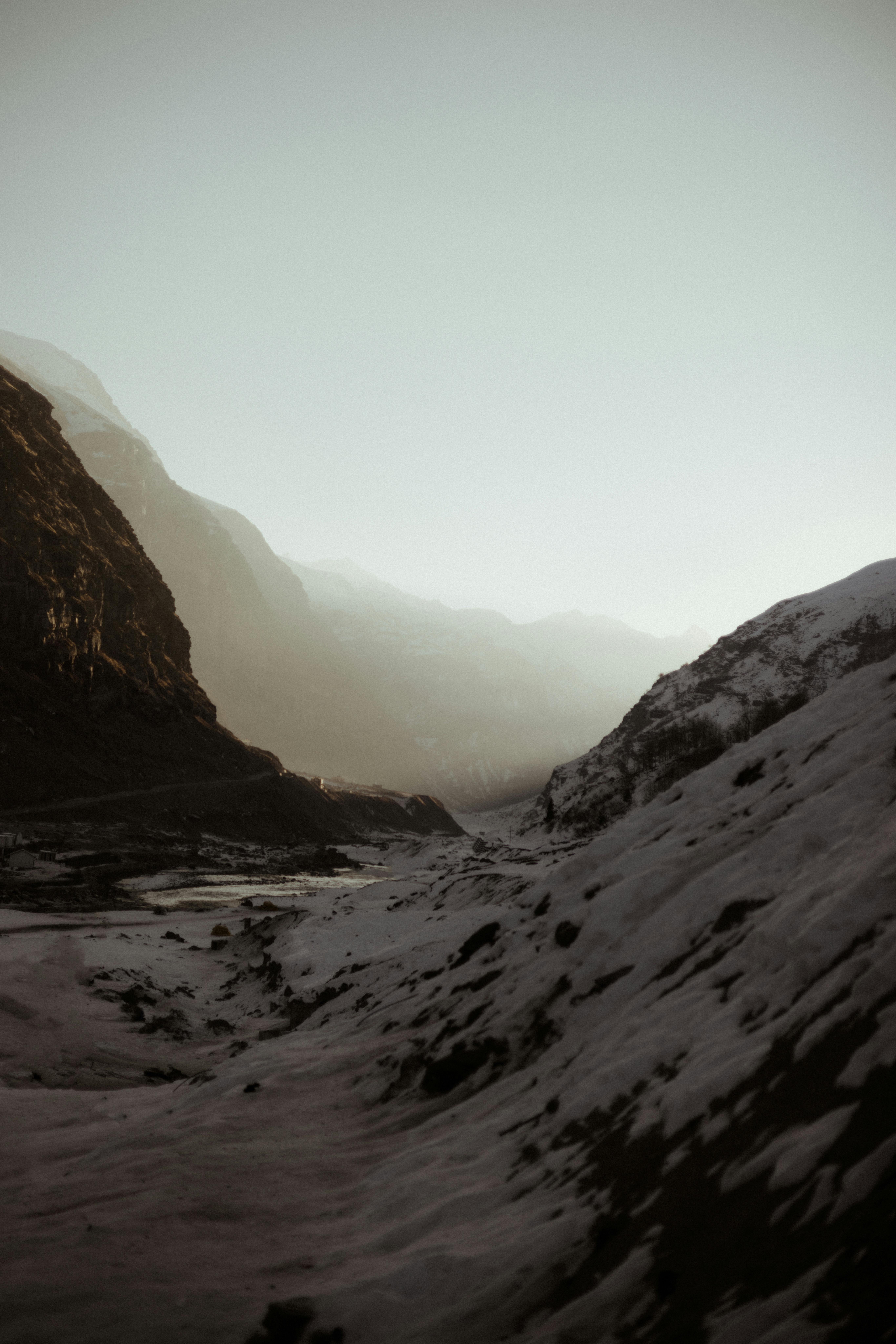 A serene winter landscape in Manali, India, showcasing snow-covered mountains at dawn.