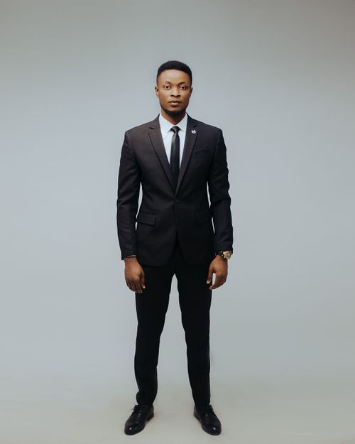 Free Professional male model in a studio wearing a sleek black suit with necktie. Stock Photo