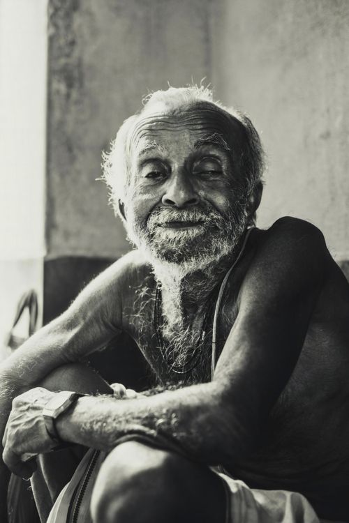 Free Close-up black and white portrait of a smiling elderly man with a beard. Captures wisdom and warmth. Stock Photo