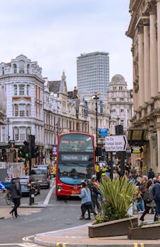 Vibrant city scene in London featuring a red double-decker bus and bustling pedestrians.