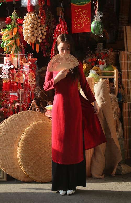 Woman in Red Dress Standing with Fan