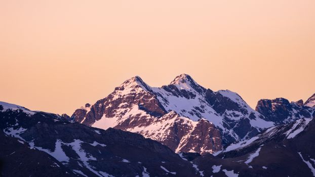 Majestic view of twin snow-capped mountains during sunset in the Pyrenees.